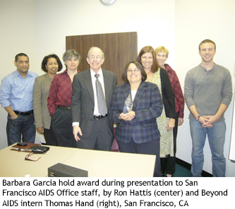 Barbara Garcia hold award during presentation to San Francisco AIDS Office staff, by Ron Hattis (center) and Beyond AIDS intern Thomas Hand (right), San Francisco, CA 